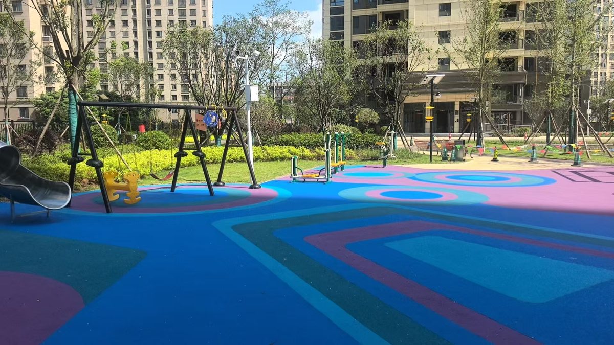 EPDM rubber safety surface in a low age play zone with a rope climbing frame and low slide Безопасное покрытие из EPDM-каучука в игровой зоне для детей младшего возраста с веревочной рамой для лазанья и низкой горкой.